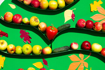 Apples, cucumbers, red peppers are in a row, art, still life.