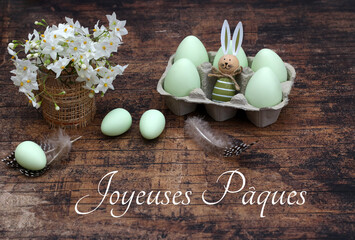 Bouquet de fleurs avec œufs de Pâques sur planche de bois minable avec le texte Joyeuses Pâques.
