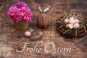 Blumenstrauß mit Ostereiern auf schäbigen Holzbrett mit dem Text Frohe Ostern.