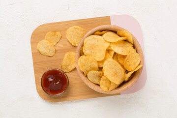 Appetizing potato chips on concrete background, top view
