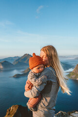 Mother hugging baby outdoor family traveling in Norway summer vacations mom with kid hiking in mountains active healthy lifestyle outdoor love motherhood childhood concept - obrazy, fototapety, plakaty