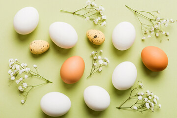 Happy Easter composition. Easter eggs on colored table with gypsophila. Natural dyed colorful eggs...