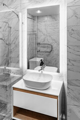 Bathroom interior with white sink, illuminated mirror and faucet