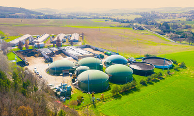 Biogas plant and farm in fields. Renewable energy from biomass. Agriculture prepared for Green...