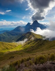 A calm blue mountain lake reflects the snow-capped peaks and fluffy white clouds of a scenic summer landscape
