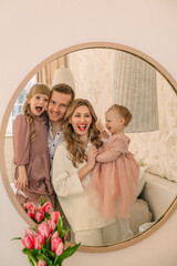 happy family of four in mirror reflection