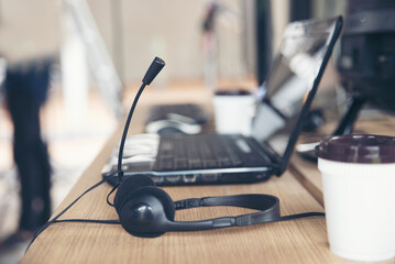 Headset and laptop for call center to contact customer placed at desk office. Headphone for...