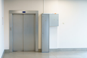 Closed elevator doors. Shiny metal elevator doors in a new modern elevator. An empty hall on the...
