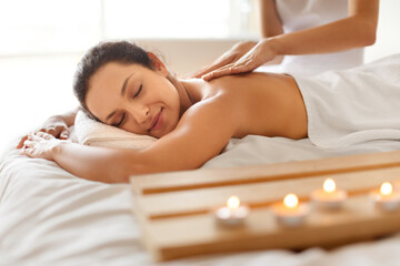 Obraz na płótnie Canvas Peaceful woman at massage session lying enjoying beauty treatment indoors