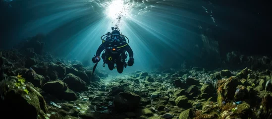 Foto op Aluminium divers pass through a cave at the bottom of the deep sea © MBRAMO