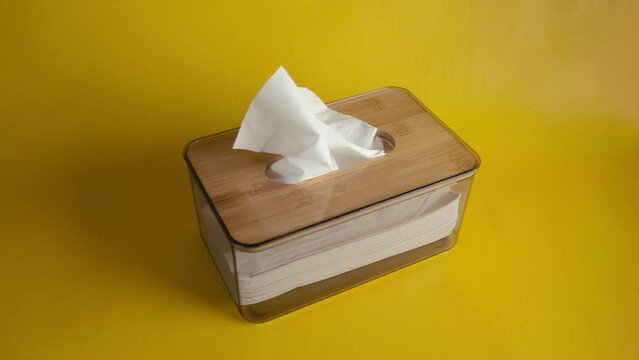 hand person put tissue box with isolated yellow background