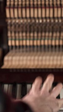 Pianist playing piano with open piano mechanism inside