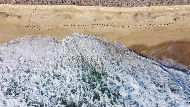 Waves break onto golden sandy beach during sunset in Baja California Sur, Mexico