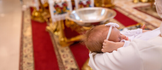 a woman holds a child in a church. baptism of a child. church.