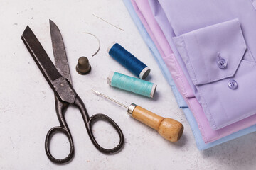 Folded shirts, scissors and other tools for home clothing repair