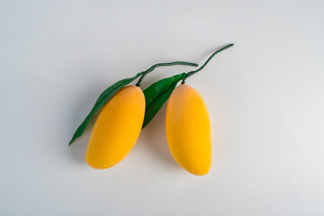 Closeup ripe mango with green leaf isolated on white background.