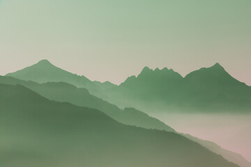 Spectacular mountain ranges silhouettes in shades of green.