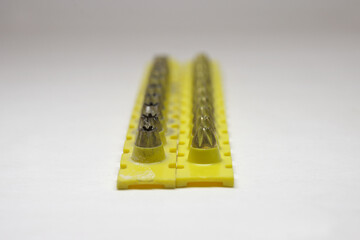 powder actuated tool loads. spent and new cartridges, inserted into pair of yellow strips, selective focus, close-up