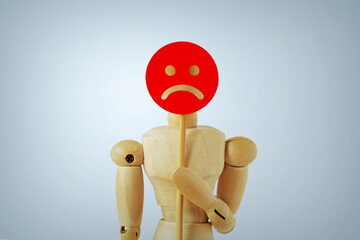 Wooden mannequin with sad face paddle - Concept of sadness, dissatisfaction and negative feedback