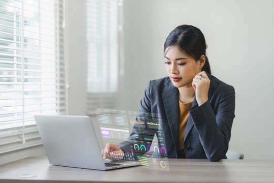 A businesswoman or accountant using laptop to analyze financial investments and business and marketing growth on a data graph. The concepts of accounting, economics, and commercial analysis.
