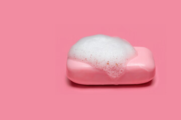 Pink soap with foam on pink background