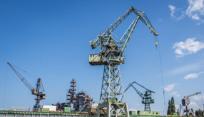 Cranes in area of Gdansk Shipyard in Gdansk city, Poland - obrazy, fototapety, plakaty