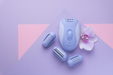 top view of Modern epilator on purple background. skin care, removal of unwanted hair.