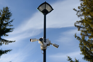 A group of surveillance cameras mounted on a lamp post