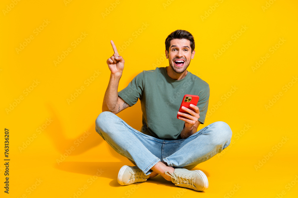 Poster full length photo of funky excited man dressed khaki t-shirt getting sms modern device pointing empt