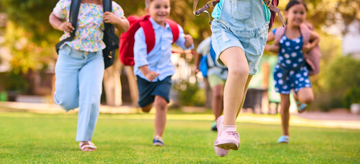 Close Up Of Primary Or Elementary School Students With Backpacks Running Outdoors At End Of Day - 763137037