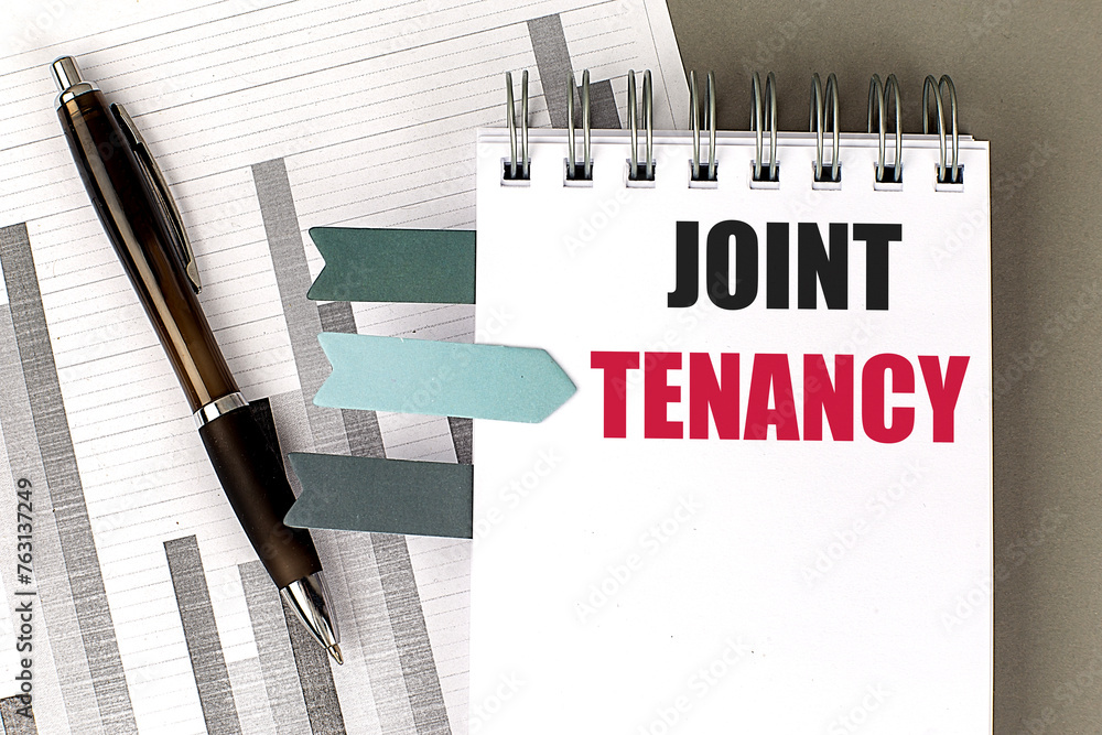 Aufkleber JOINT TENANCY text on notebook with chart on gray background