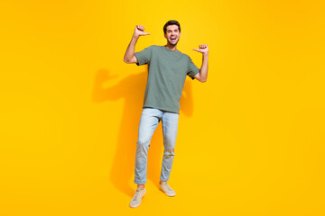 Full length photo of funky excited guy wear khaki t-shirt walking showing thumbs himself isolated yellow color background
