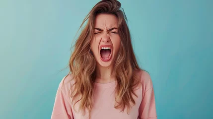 Fotobehang The young emotional angry woman screaming on pastel blue background ©  Mohammad Xte