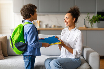 Son taking school items from mother