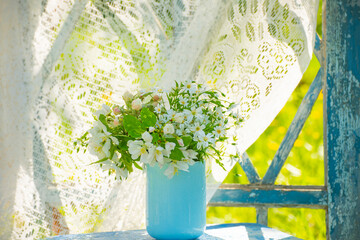 delicate spring bouquet on a vintage wooden window in a sunny garden.