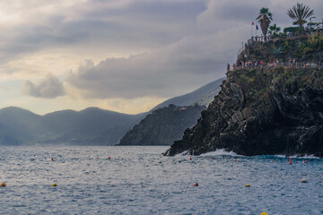 Mediterranean sea and cliff with trail and Corniglia at the top and gradient mountain in the background, Manarola ITALY