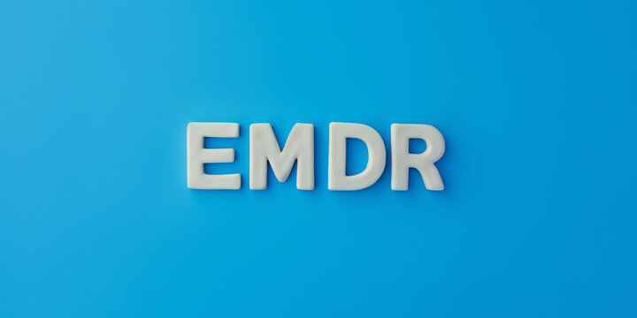 Letters EMDR written on blue background. Eye Movement Desensitization and Reprocessing psychotherapy treatment concept.