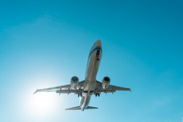 Fototapeta na wymiar Airplane in the sunny sky landing approach.