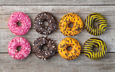 Set of colorful donuts on wooden background