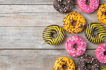 Set of colorful donuts on wooden background