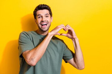 Portrait of cheerful thankful guy with stubble wear stylish t-shirt showing heart symbol smiling...