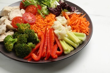 Balanced diet and healthy foods. Plate with different delicious products on white marble table, closeup