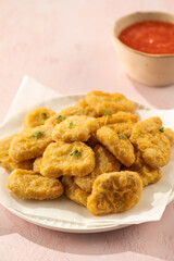 Delicious golden chicken nuggets on a plate on the table. Fast food, menu.