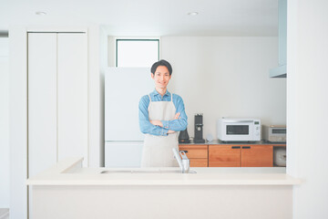 Fototapeta na wymiar キッチンに立つエプロン姿の男性