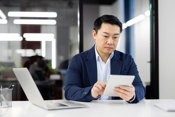 Fototapeta na wymiar Professional businessman using tablet in modern office