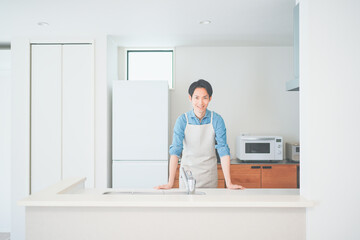 キッチンに立つエプロン姿の男性