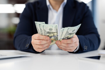 Businessman holding cash in hands at office