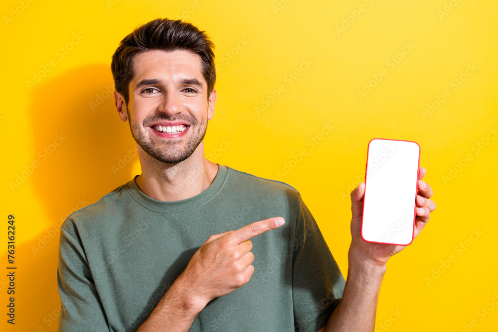 Poster photo of intelligent pleasant man dressed khaki t-shirt directing at smartphone display empty space 