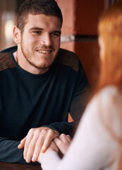 Happy couple, bonding and holding hands with romance in support, trust or care at indoor restaurant. Young man or woman with smile in happiness for social, conversation or friendly discussion at cafe