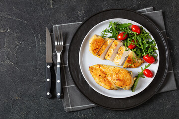 fried chicken breasts with green salad on plate